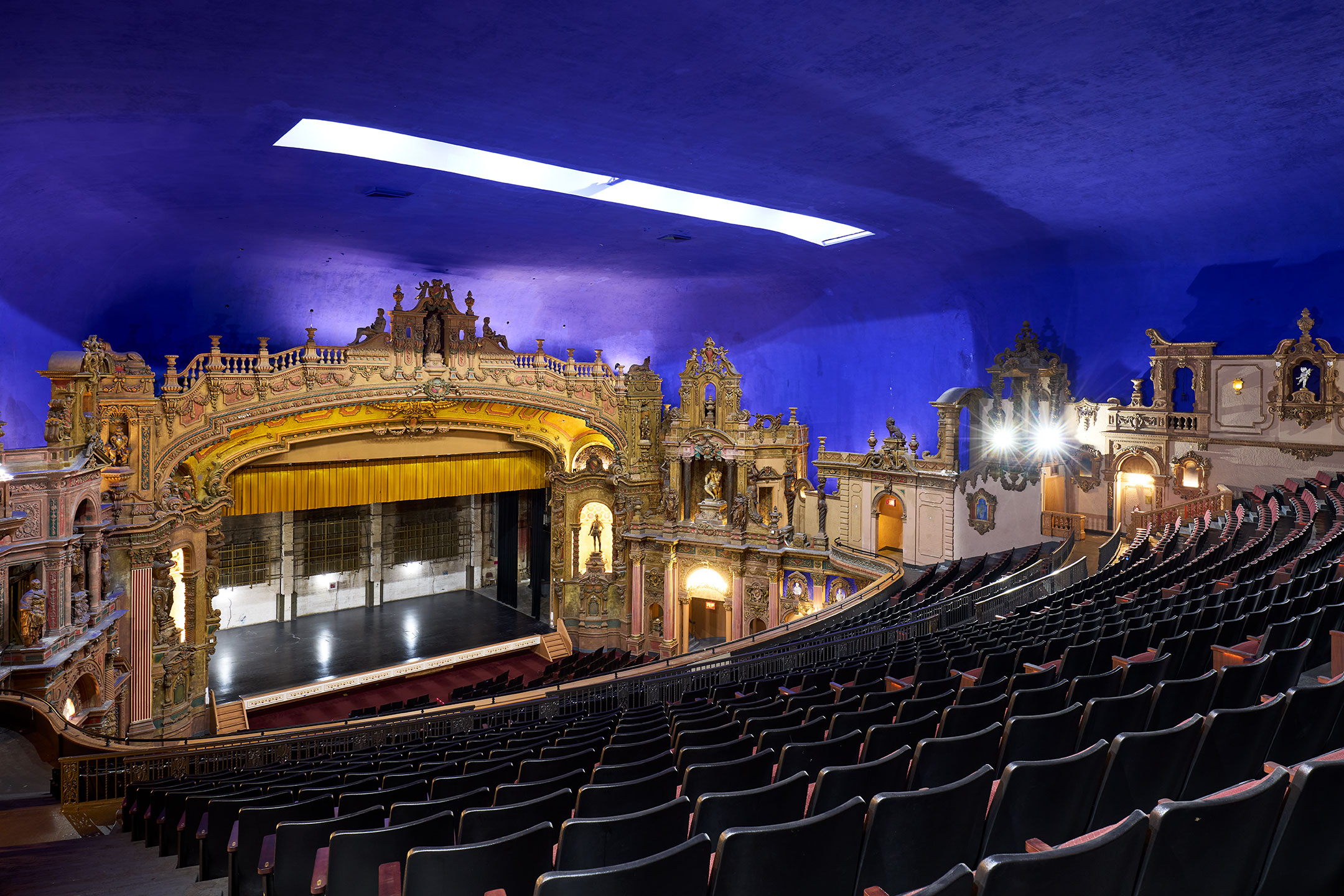 A view across the curved seating rows toward the golden proscenium.